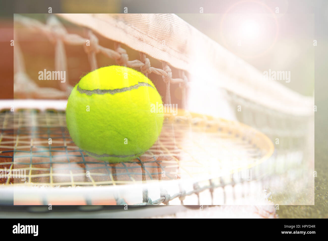tennis ball and tennis racket on a tennis court with blurred background Stock Photo