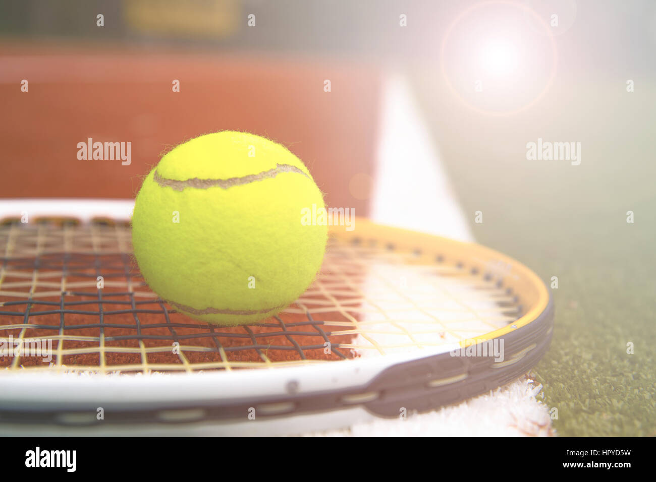 tennis ball and tennis racket on a tennis court with blurred background Stock Photo