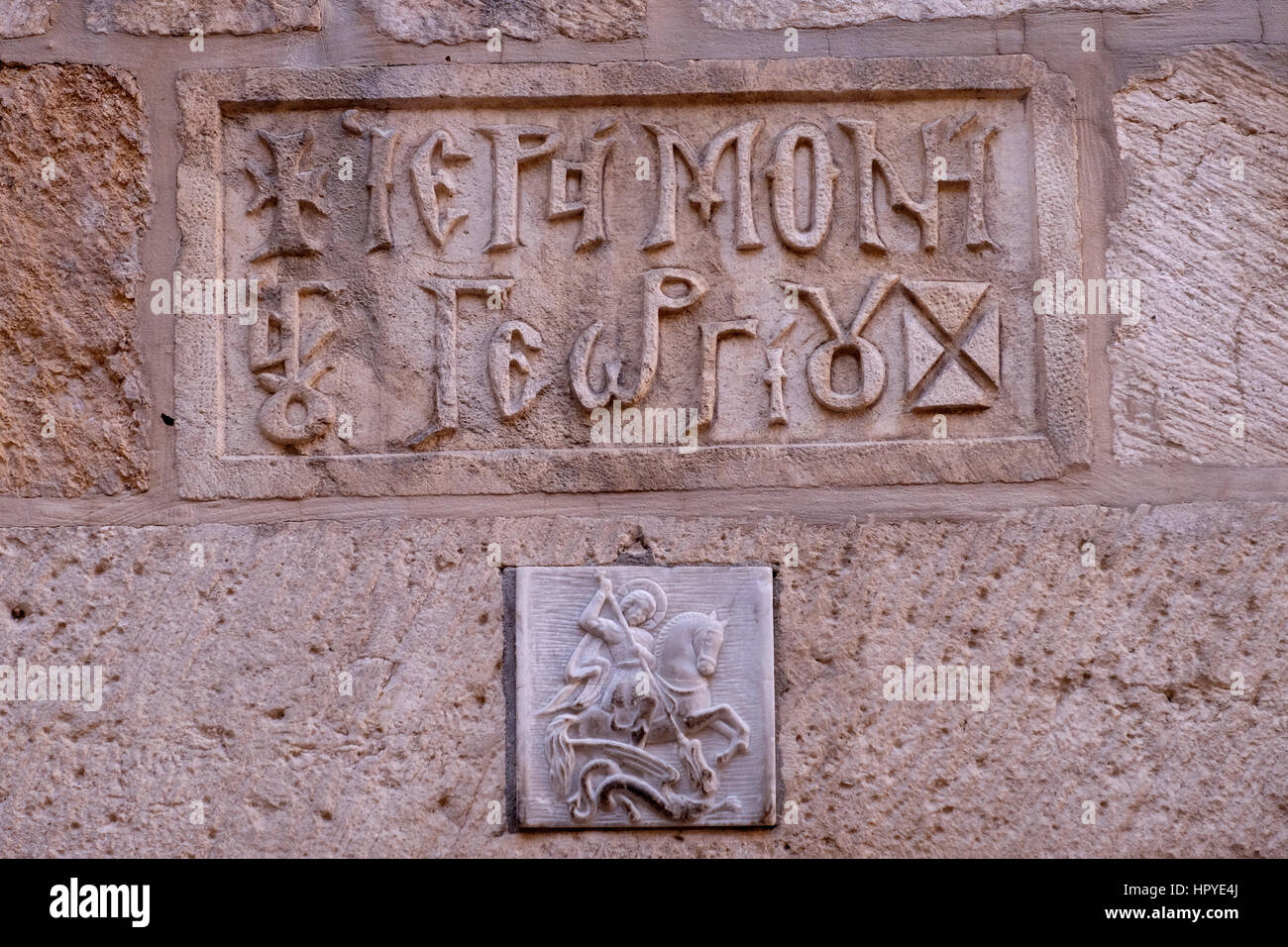 A carved figure depicting an orthodox Christian legend in which Saint George slays a dragon that demanded human sacrifices at entrance to the St. George Monastery in St Francis street in the Christian Quarter old city East Jerusalem Israel Stock Photo