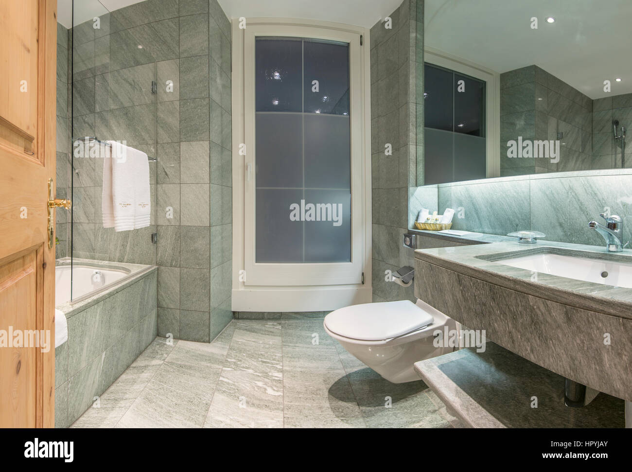 Modern minimalistic hotel bathroom with marble tiles covered walls interiors Stock Photo
