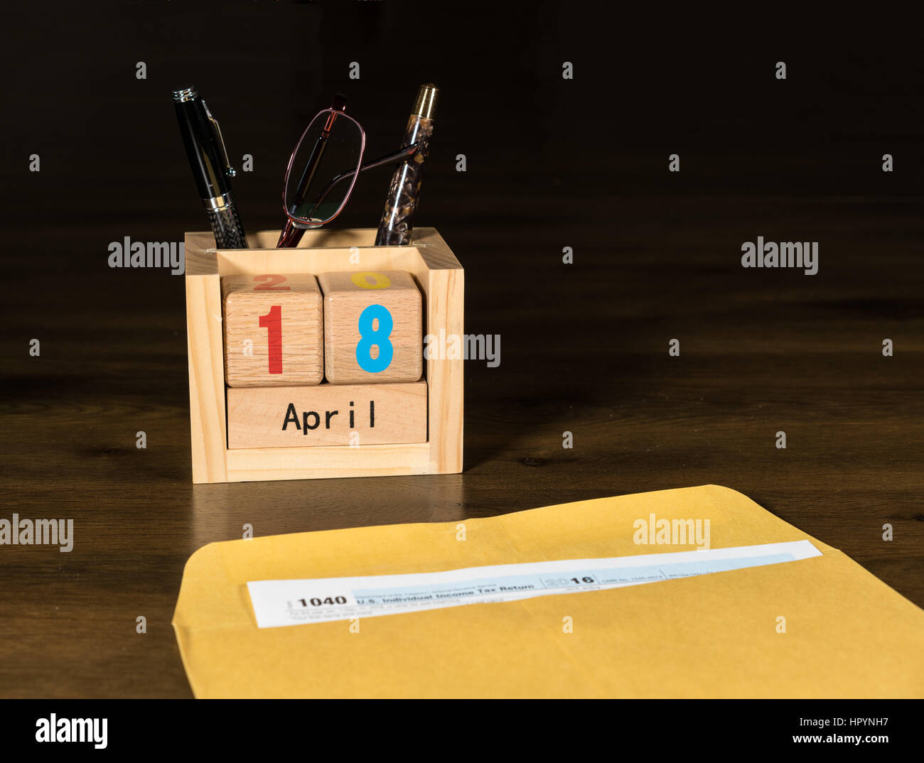 Wooden letters in calendar with Form 1040 income tax for 2016 showing tax day for filing is April 18 2017 Stock Photo