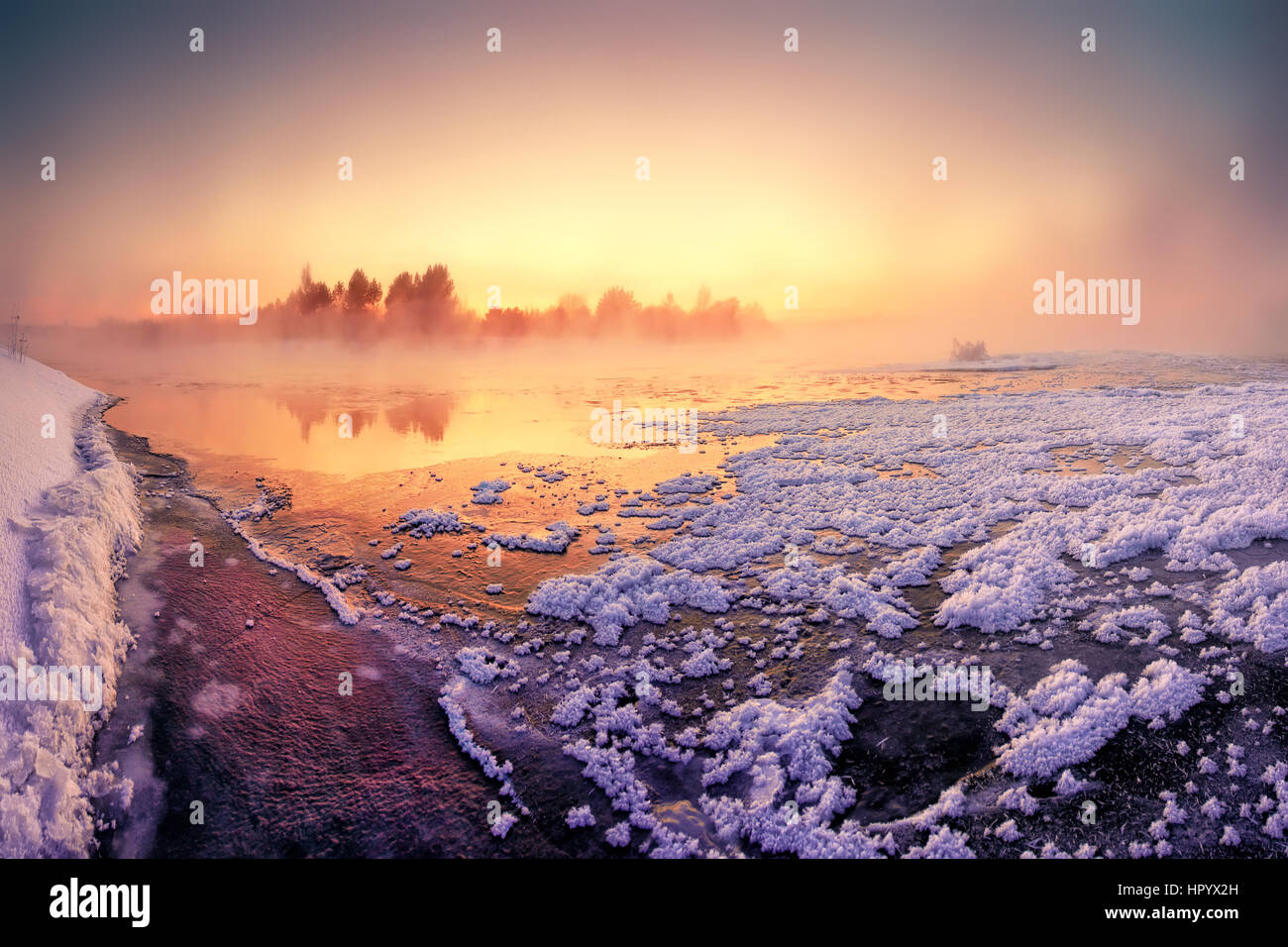 Colorful winter morning on lake covered by snow Stock Photo