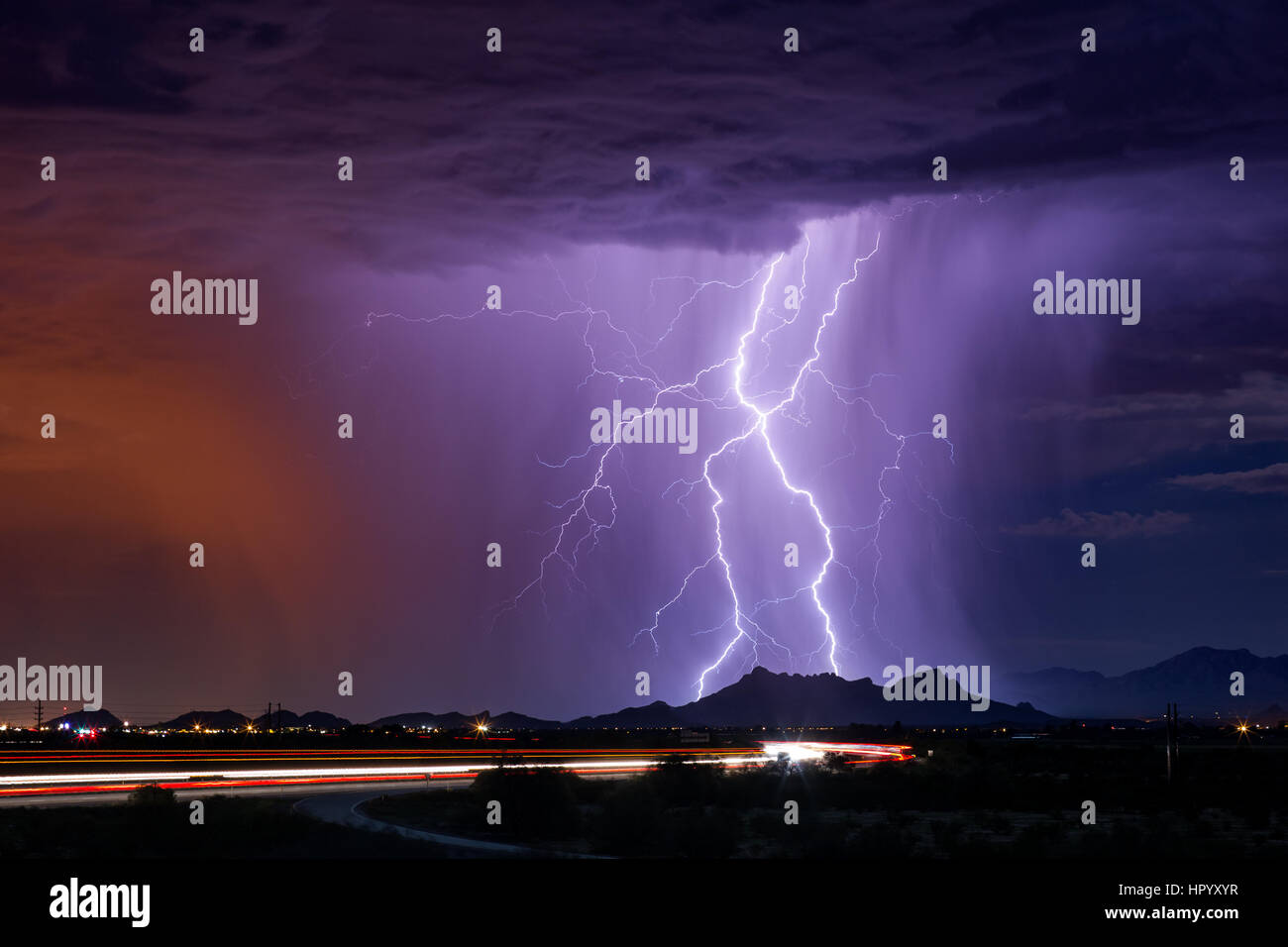 Vivid lightning bolts strike a mountain during a monsoon thunderstorm in Tucson, Arizona Stock Photo