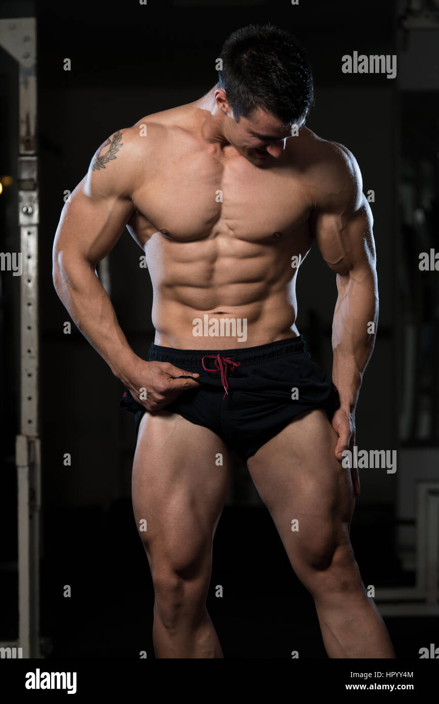 Muscular Man Flexing Abdominal Muscles Abs In A Health Club Stock Photo -  Alamy