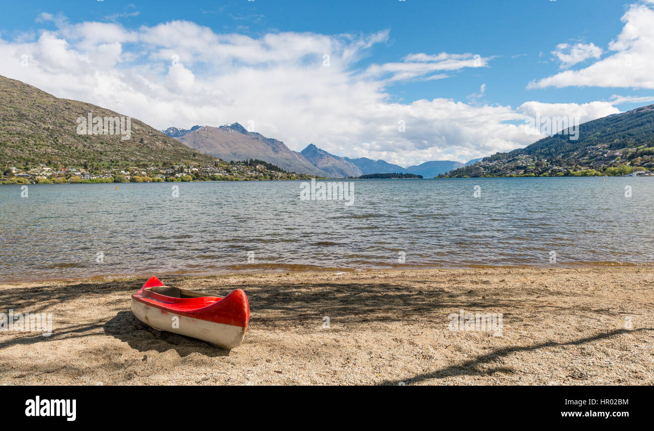 Red kayak on beach, Lake Wakatipu, Queenstown, Otago Region, Southland, New Zealand Stock Photo
