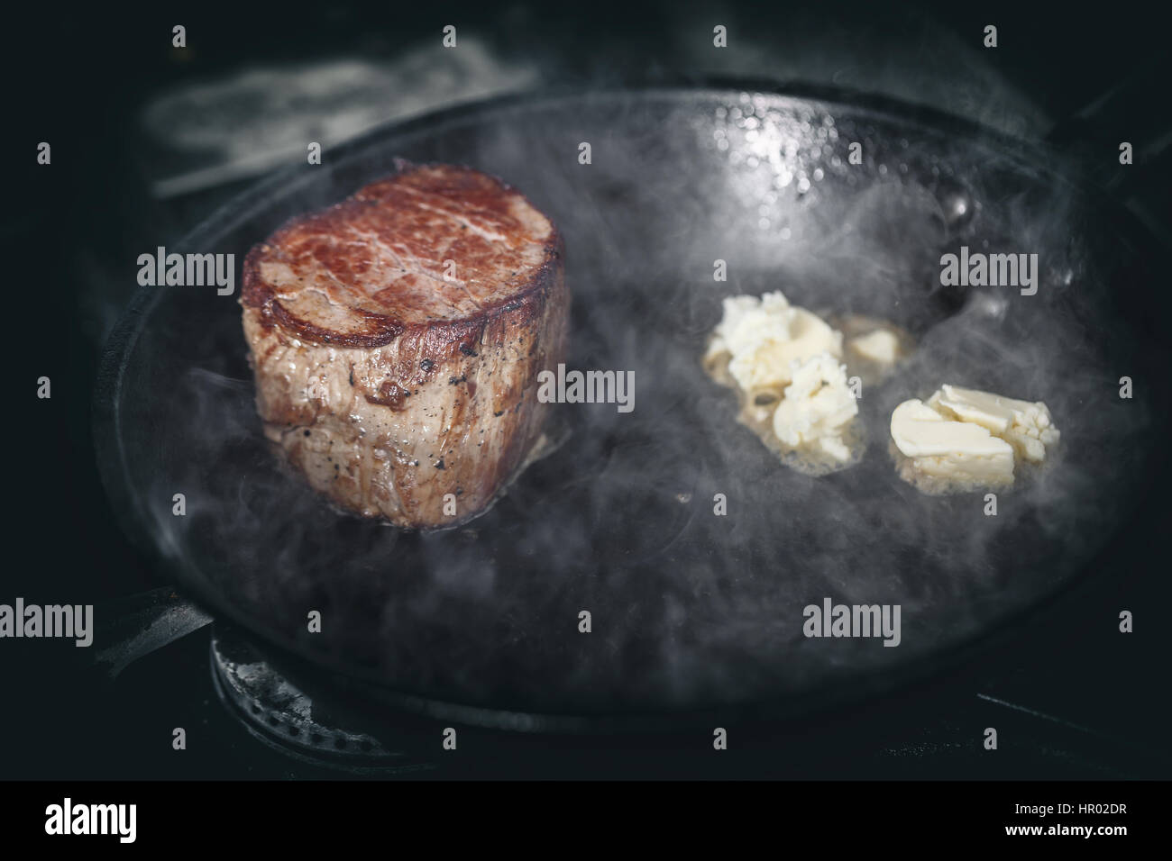 Piece of beef meat frying in the pan with butter Stock Photo