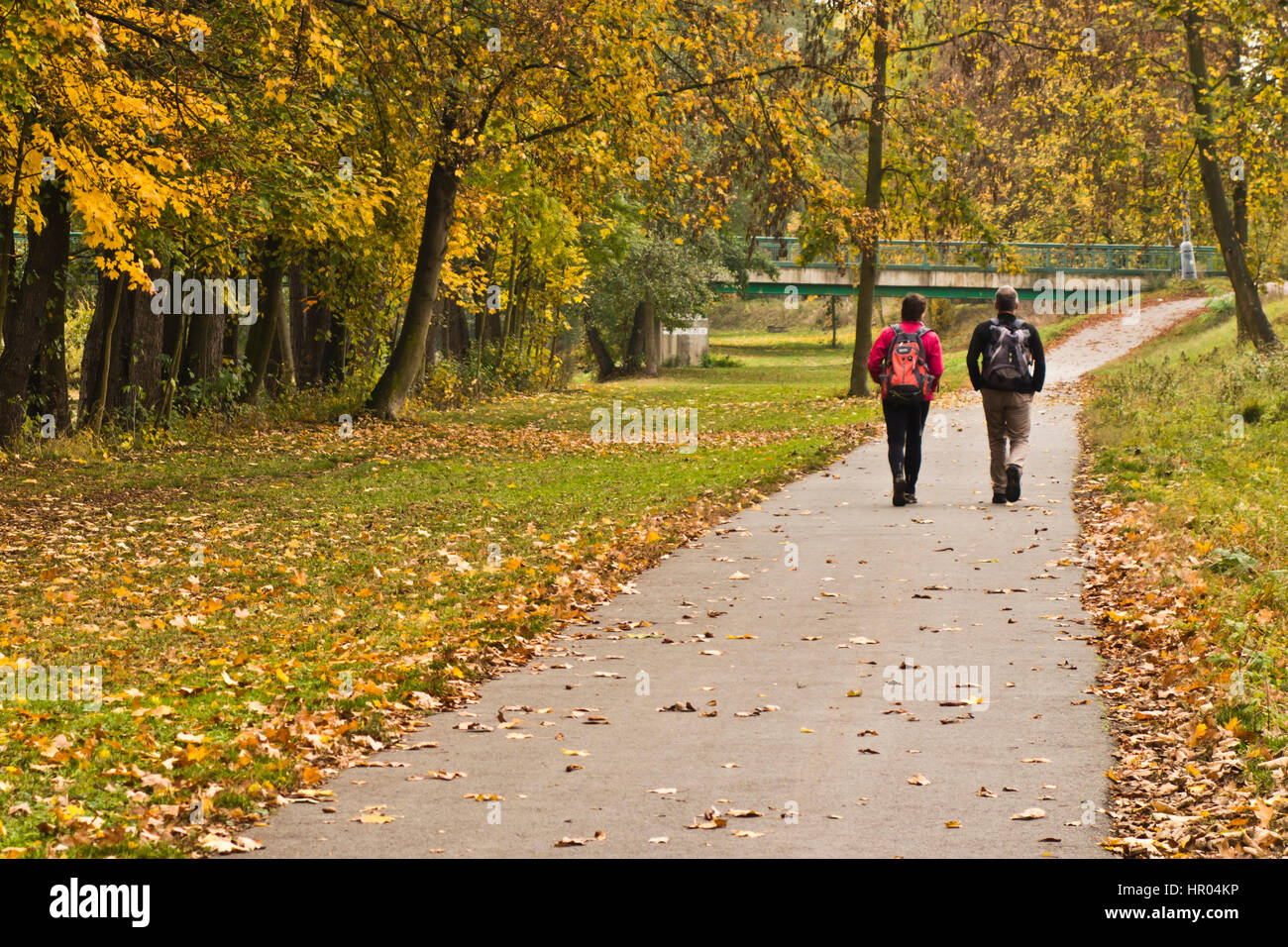 couple travelers with backpacks walking in natural surroundings Stock Photo