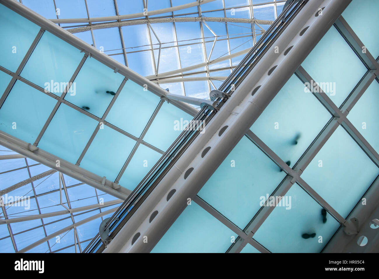 modern office building with diagonal crossing transparent bridges  with footprints from people standing on it. Stock Photo
