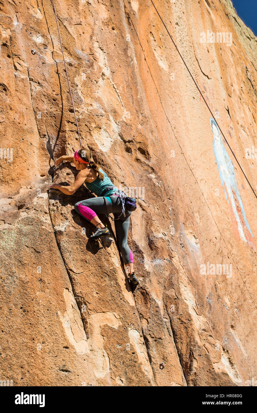 Young woman rock climbing by Virgin of Guadalupe painting; Penitente Canyon; Colorado; US; Penitente Canyon; Colorado; US Stock Photo