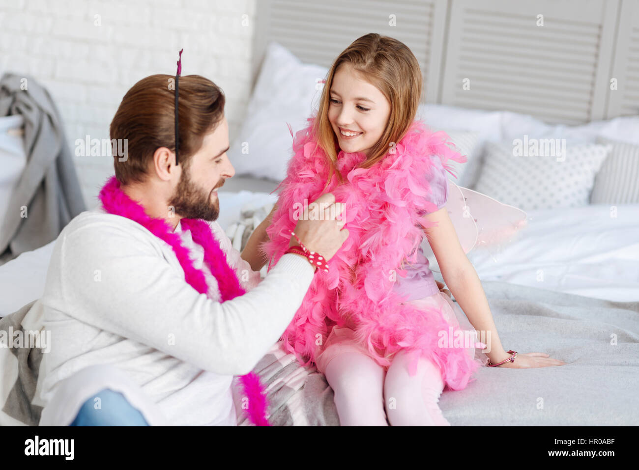 Love you dad. Joyful smiling girl wearing costume for princess keeping  hands on the bed turning head to her daddy Stock Photo - Alamy