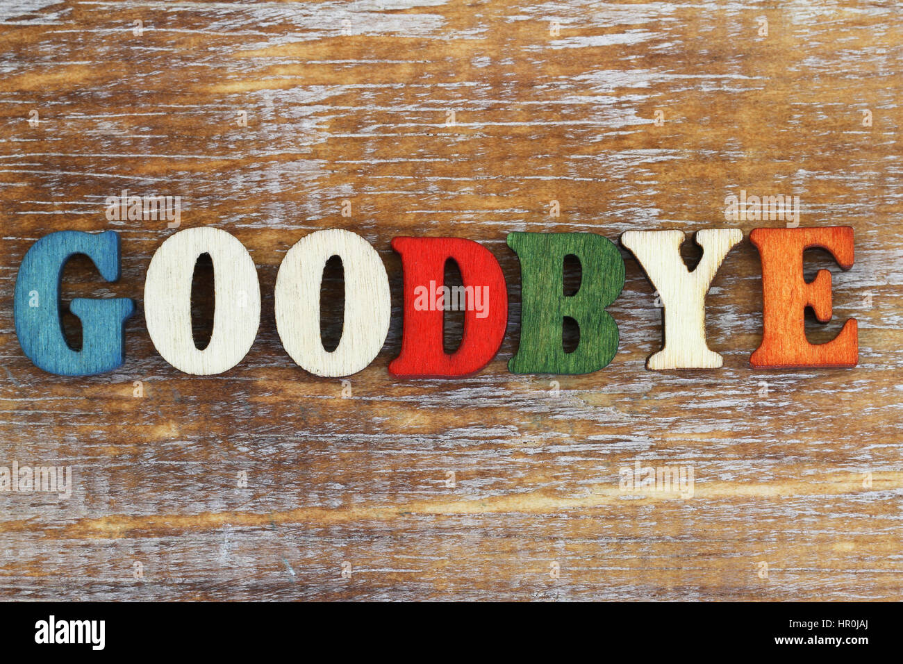 Goodbye written with colorful letters on rustic wooden surface Stock Photo