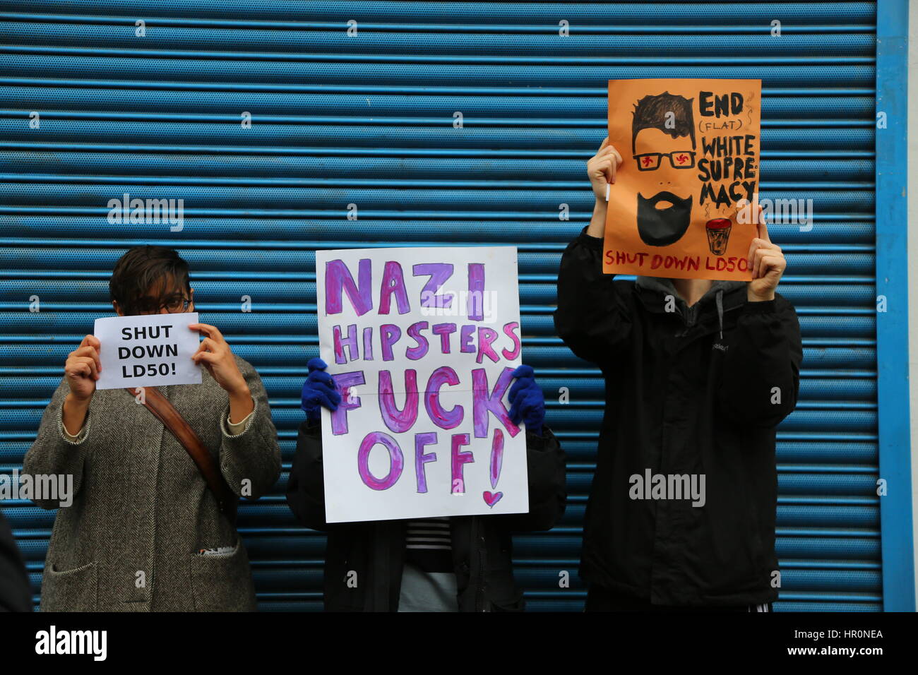 Dalston, London, UK. 25th February, 2017. Three demonstator with placards outside the LD50 gallery. A protest outside the LD50 Gallery organised by Hackney Stands Up To Racism and Fascism and Unite Against Fascism. Artists and campaigners are protesting calling for the closure of LD50, in Dalston, east London, after accusations the gallery gave a platform to anti-immigrant, Islamophobic and “alt-right” figures and promoted “hate speech not free speech”. Penelope Barritt/Alamy Live News Stock Photo