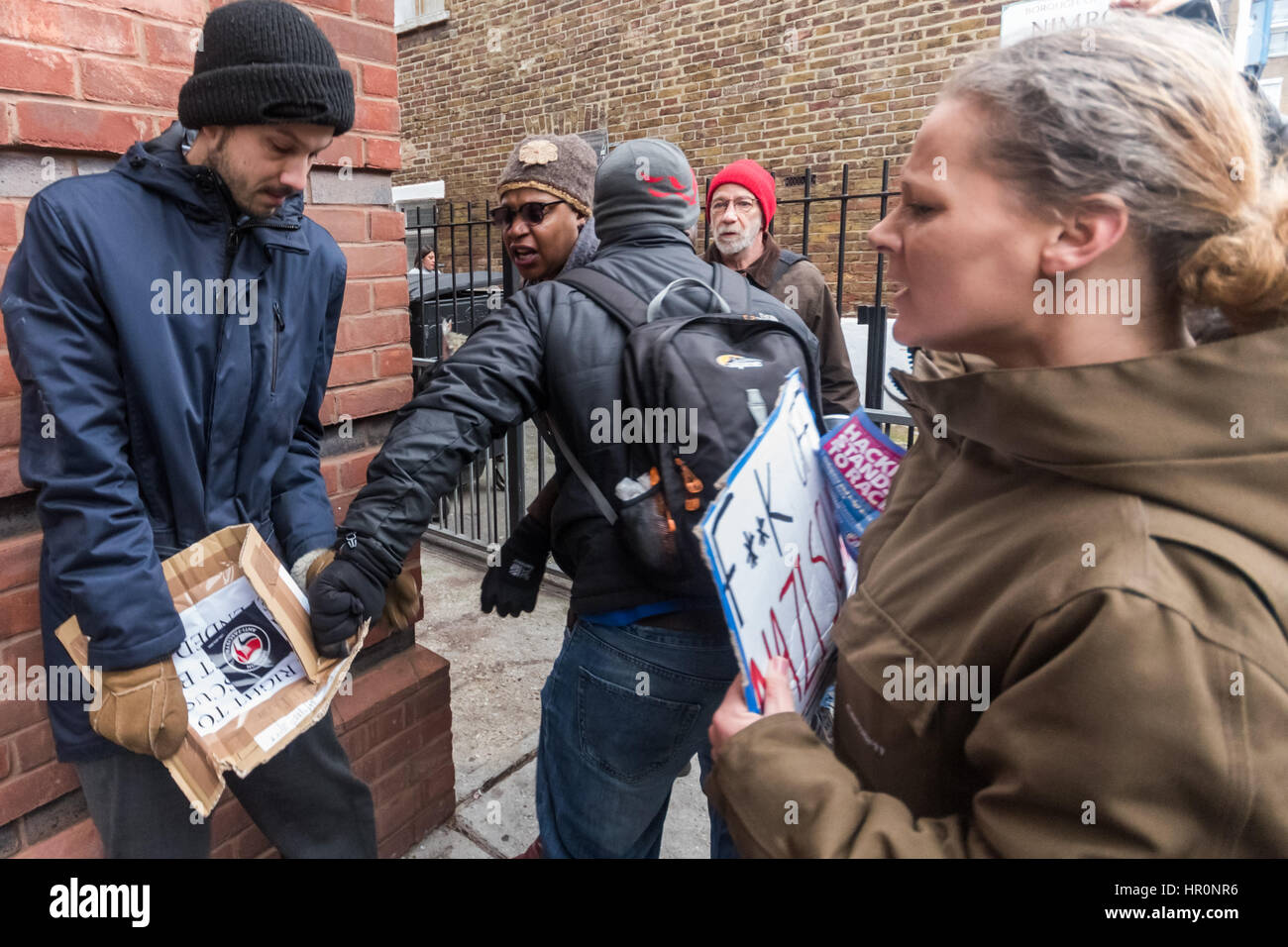 London, UK. 25th February 2017.  Protesters try to grab a poster from a man outside the LD50  gallery in Dalston who says he has come to defend that the right to freely discuss ideas, even repulsive ones. He was shouted at by protesters and eventually police took him aside and advised him to leave. Several hundred people from East London had gathered outside the  gallery which they say has promoted fascists, neo-Nazis, misogynists, racists and Islamophobes in one of London's more diverse areas. Credit: Peter Marshall/Alamy Live News Stock Photo
