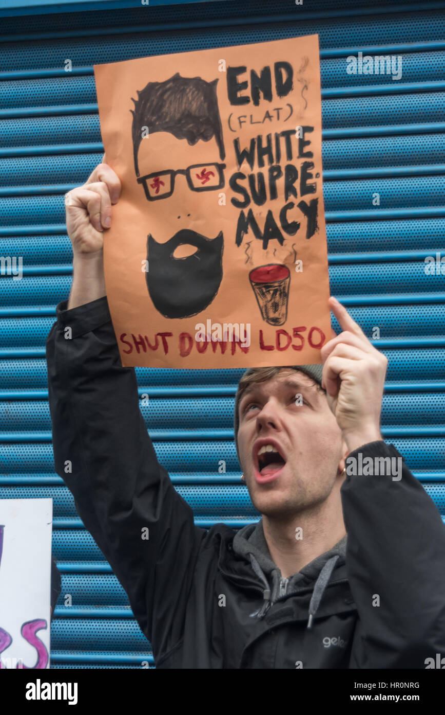 London, UK. 25th February 2017. One of several hundred protesters from East London outside the LD50 gallery in Dalston holds a poster against white supremacist hipsters calling for the LD 50 gallery to be shut down. Protesters say the gallery in one of London's more diverse areas has promoted fascists, neo-Nazis, misogynists, racists and Islamophobes and 'has been responsible for one of the most extensive neo-Nazi cultural programmes to appear in London in the last decade. Credit: Peter Marshall/Alamy Live News Stock Photo