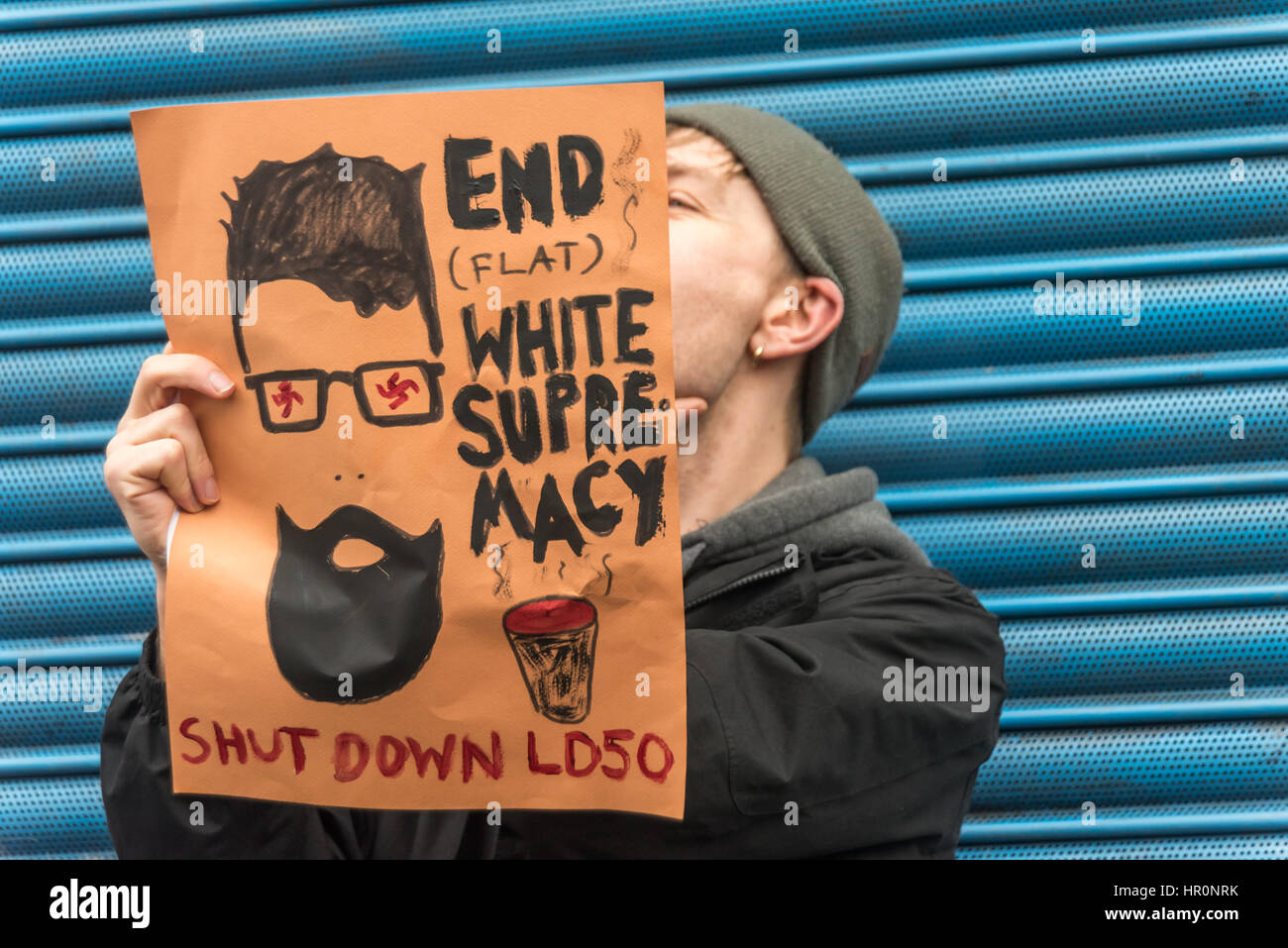 London, UK. 25th February 2017. One of several hundred protesters from East London outside the LD50 gallery in Dalston holds a poster against white supremacist hipsters calling for the LD 50 gallery to be shut down. Protesters say the gallery in one of London's more diverse areas has promoted fascists, neo-Nazis, misogynists, racists and Islamophobes and 'has been responsible for one of the most extensive neo-Nazi cultural programmes to appear in London in the last decade. Credit: Peter Marshall/Alamy Live News Stock Photo