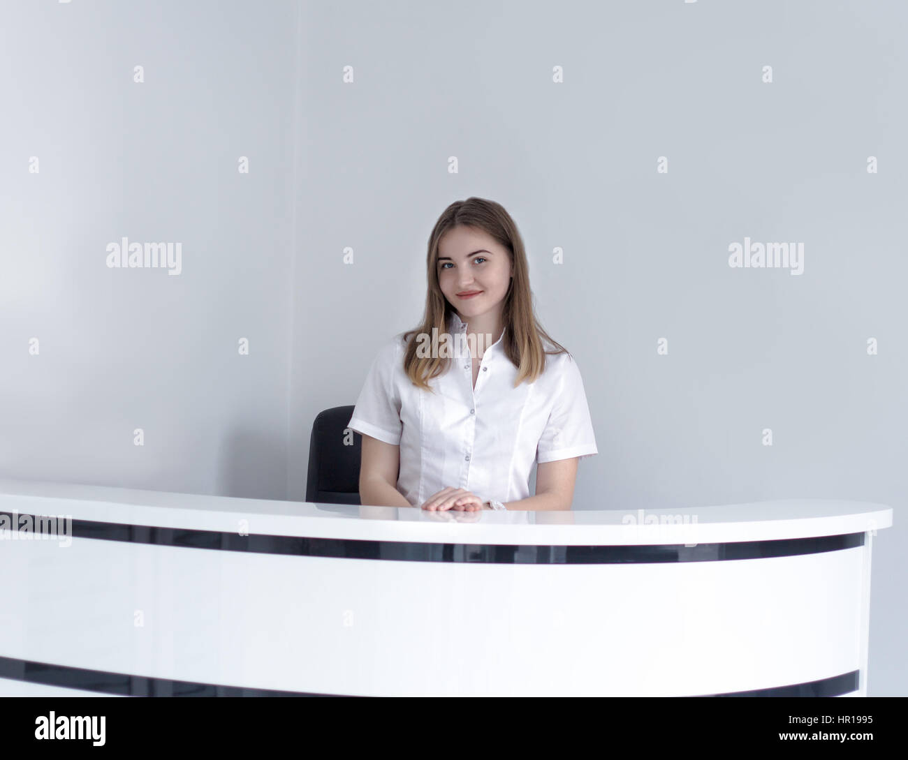 Young receptionist at hospital or medical clinic waiting for patient