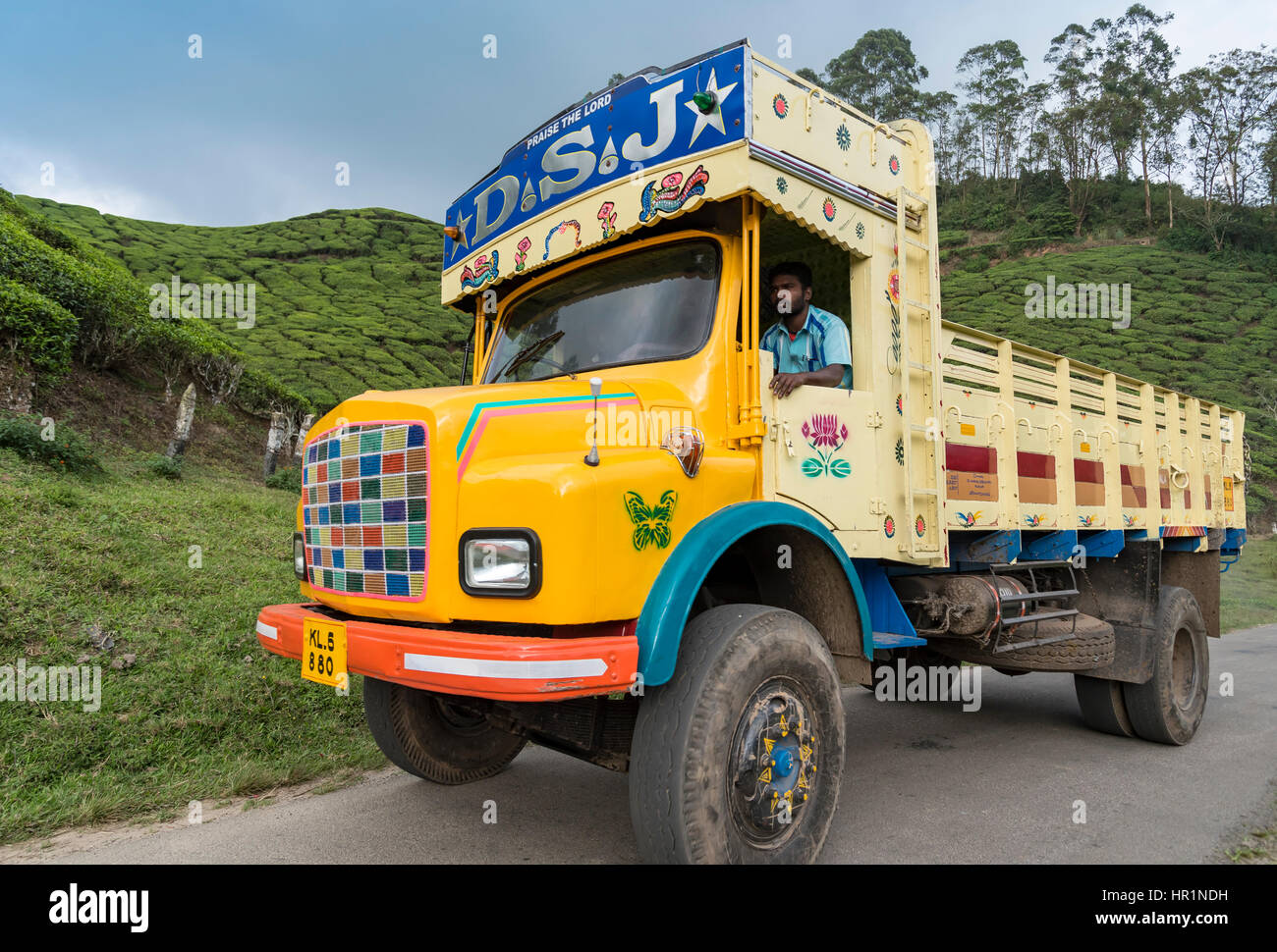 Colourful truck drives through Madupatty Tea plantation, Munnar, Kerala, India Stock Photo