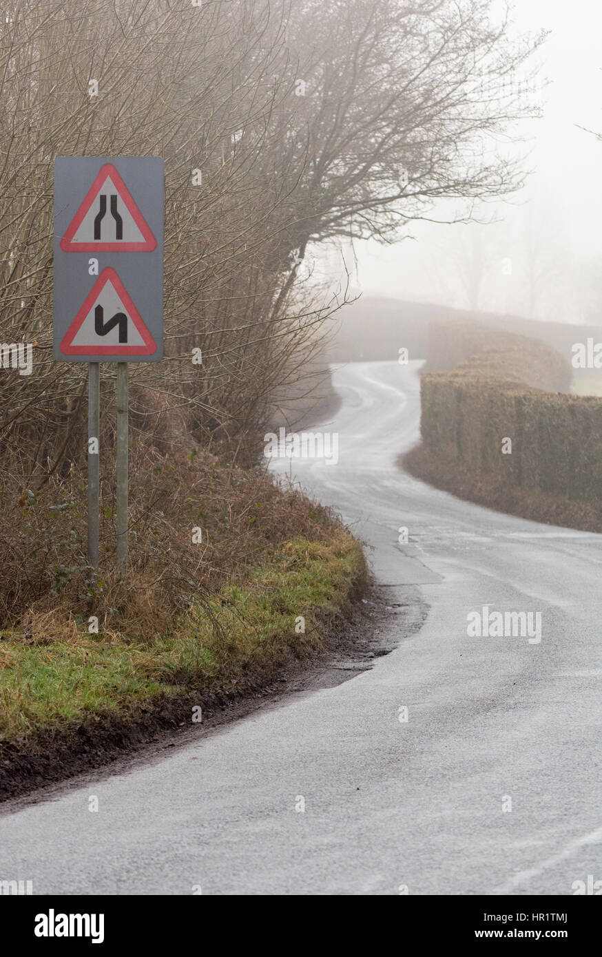 Road narrows and double bends, first to the left, on a road in Wales with light winter fog. Near the Glanusk Estate in Brecon National Park Stock Photo