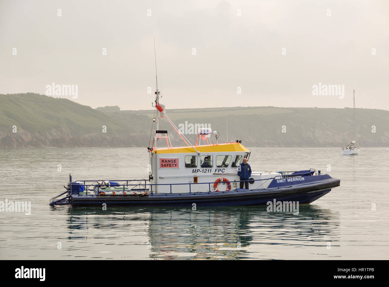 Range safety patrol boat Smit Merrion touring anchored boats in Dale before heading out to patrol the firing ranges of South Pembrokeshire Stock Photo