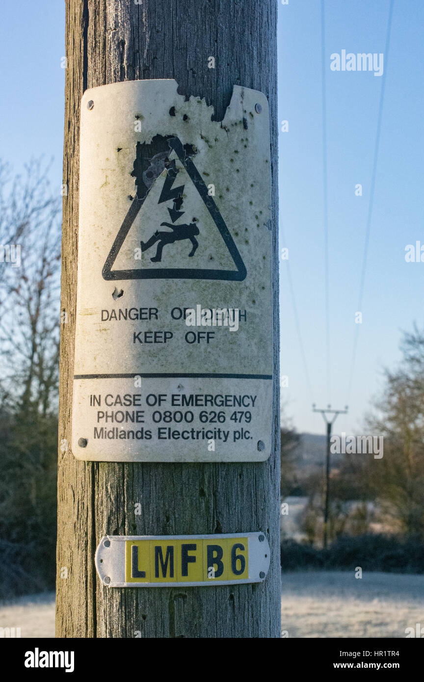 Danger of Death sign on power cable pole that has been shot many times over the years Stock Photo