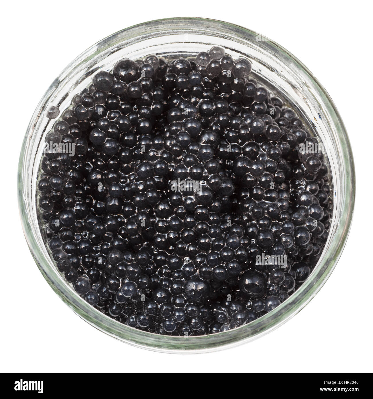 above view of black dyed salty caviare of halibut fish in glass jar isolated on white background Stock Photo