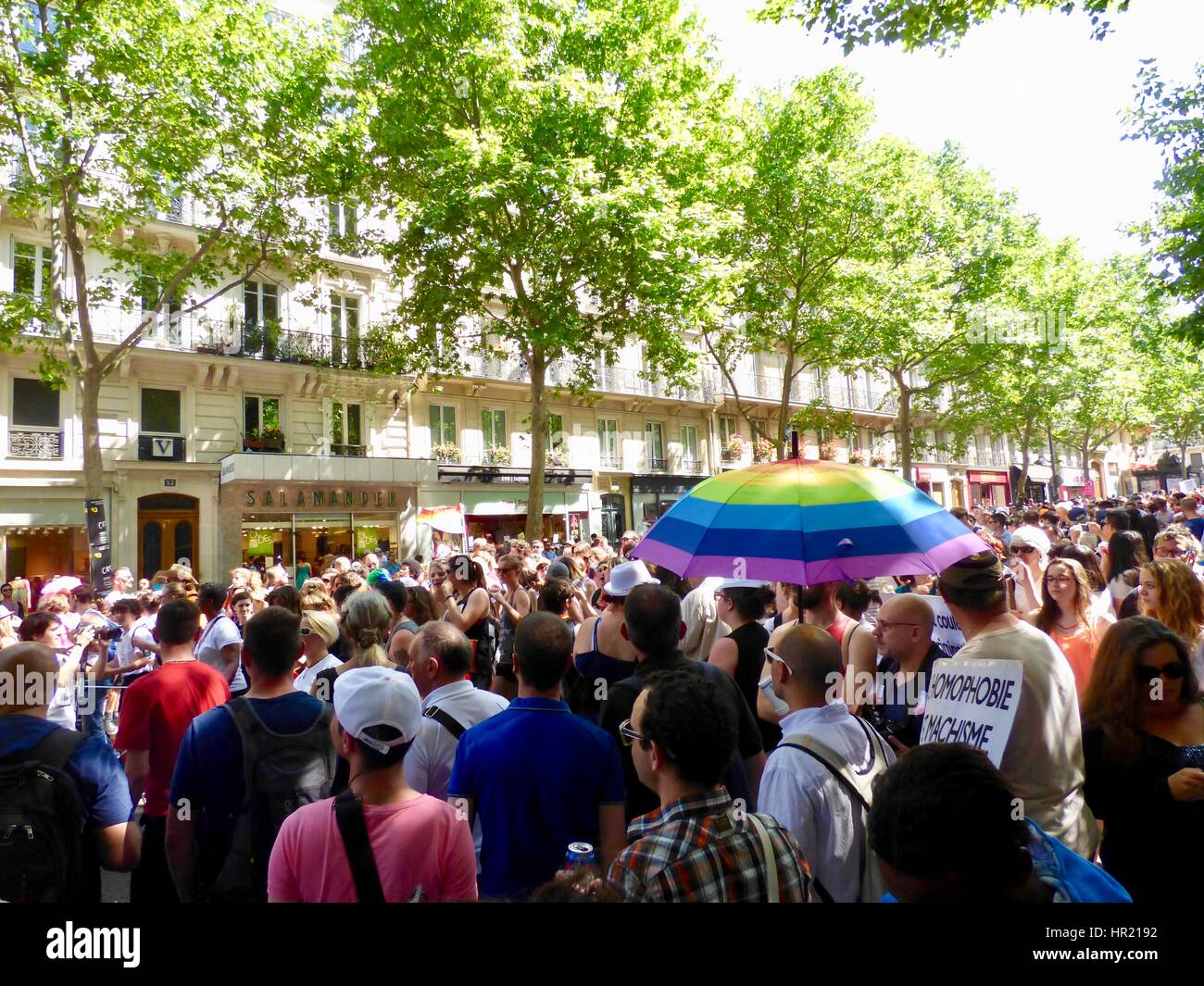 Paris Pride parade 2015, Marche des Fiertés, crowded blvd Saint-Michel, with various people and one pride colored umbrella. Paris, France. Stock Photo