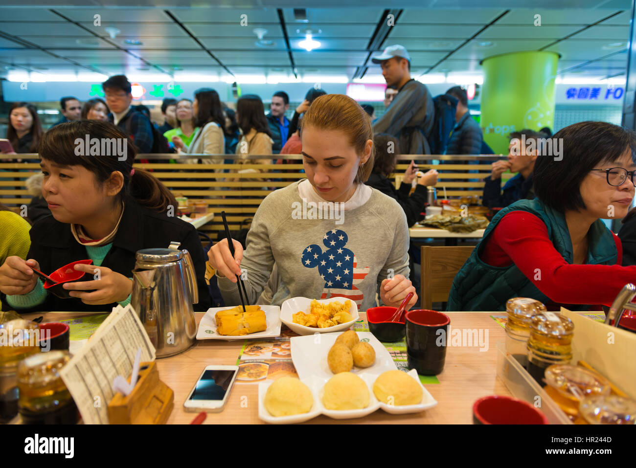 Girl eats dim sum and spring rolls in Michelin star fast food restaurant in Hong Kong Stock Photo