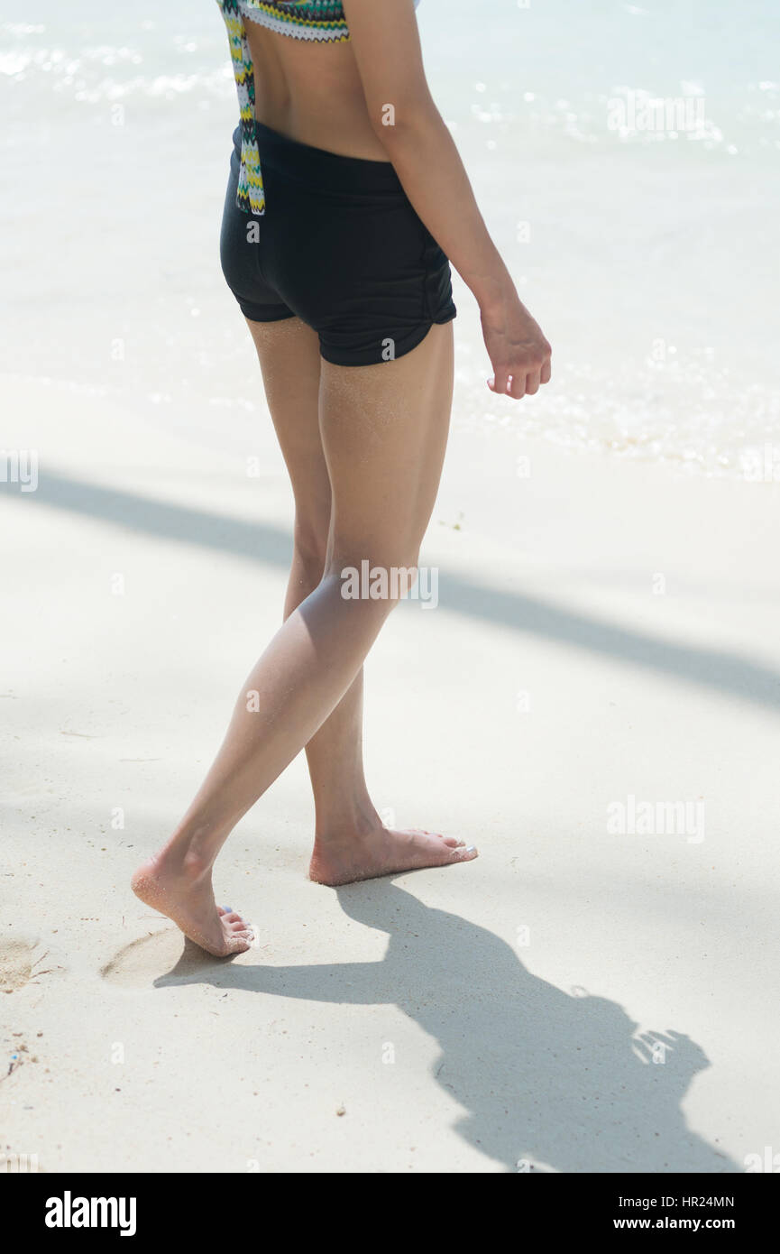 woman walking on sand beach leaving footprints in the sand Stock Photo ...