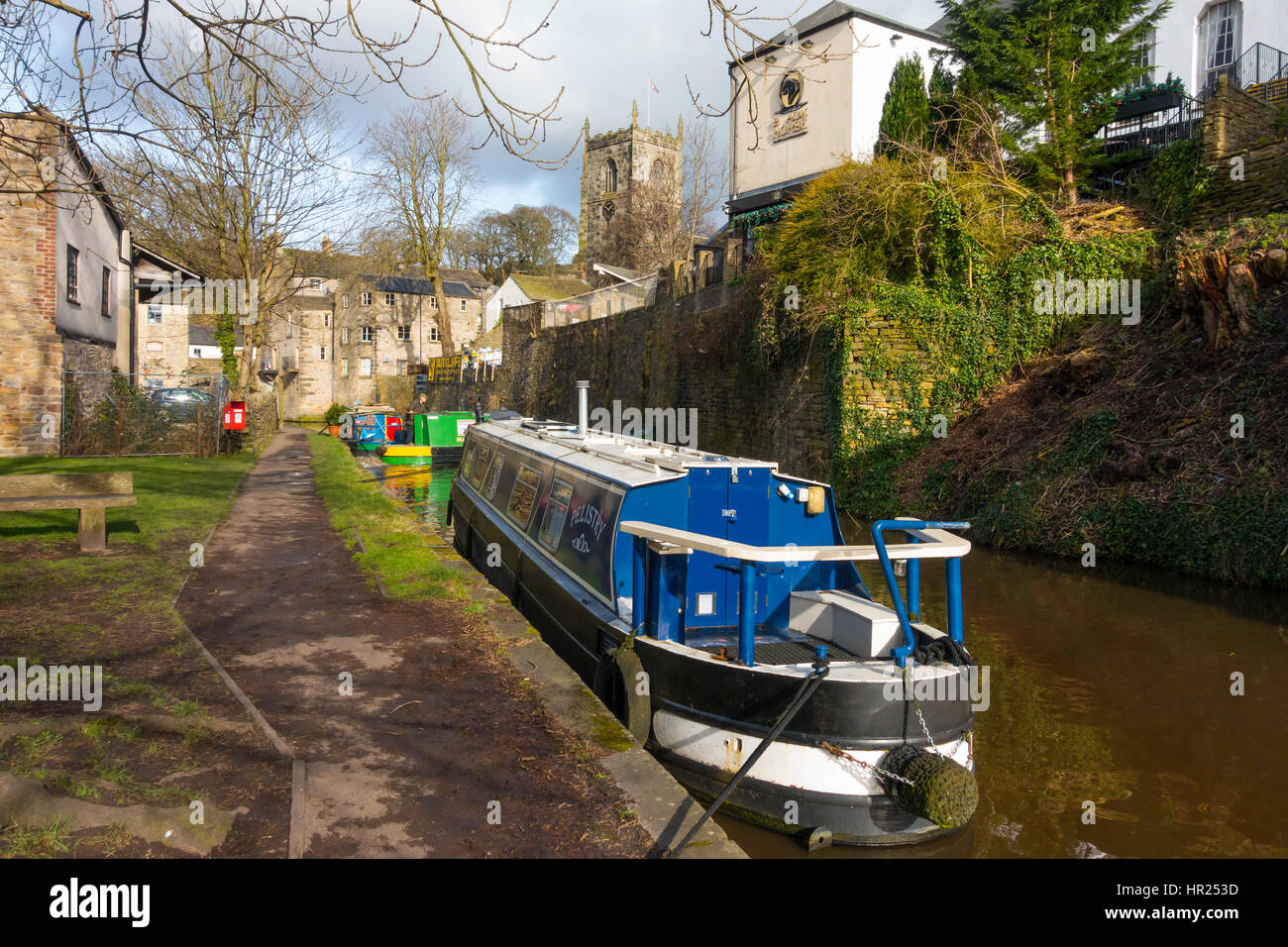 Canal narrow boats on the Leeds-Liverpool canal in Skipton  North Yorkshire, .near the town centre with the tower of Holy Trinity Church Stock Photo