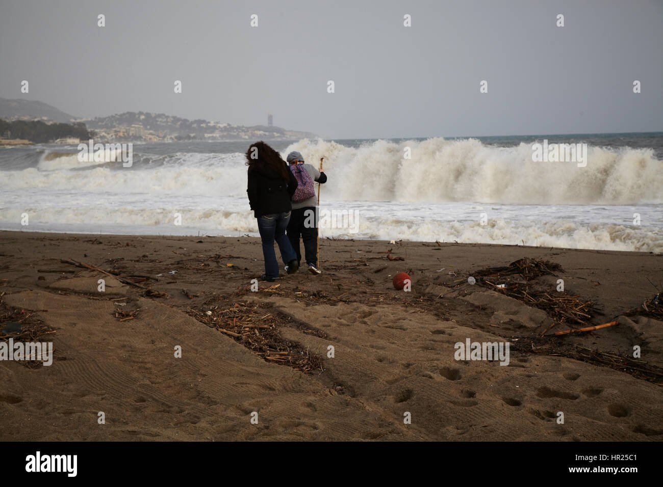 Two girls looking att  big waves in the beach of Malaga. Stock Photo