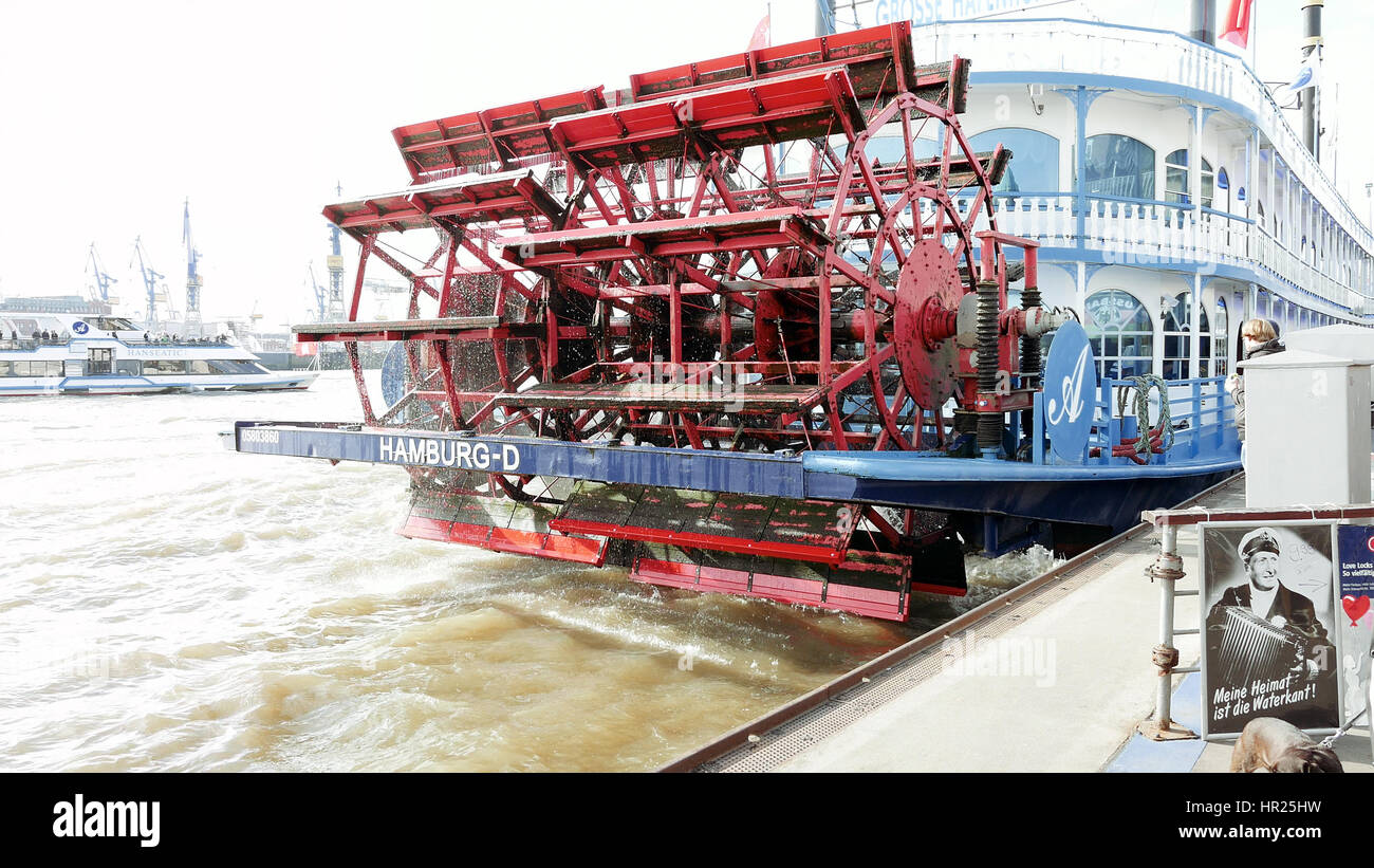 Hamburg, Germany - October, 10, 2016: Spinning paddle wheel on back side of boat docked in sea port. Moving engine part of ship moored to pier. Anchor Stock Photo