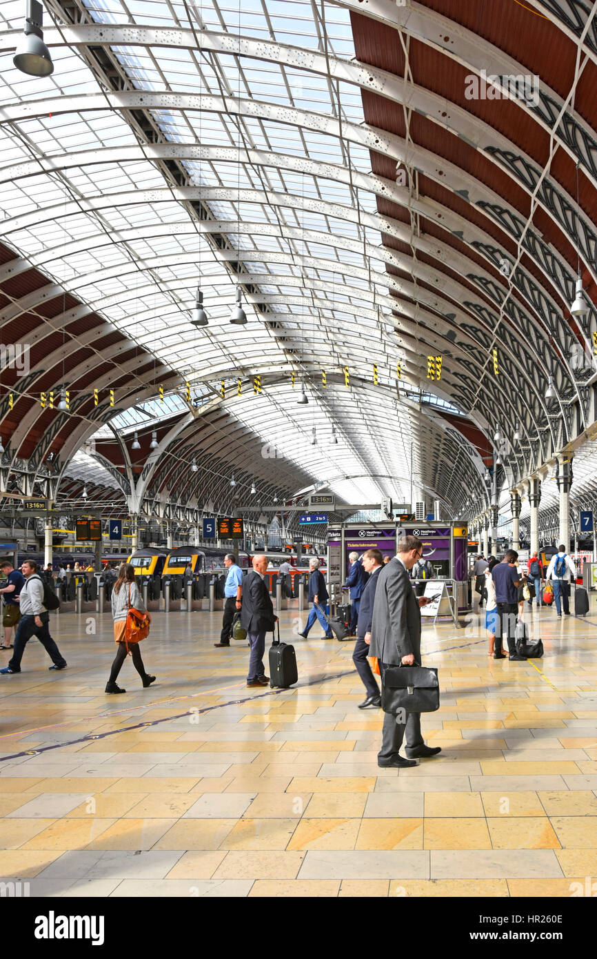 Passengers at Paddington train station concourse London UK with ticket