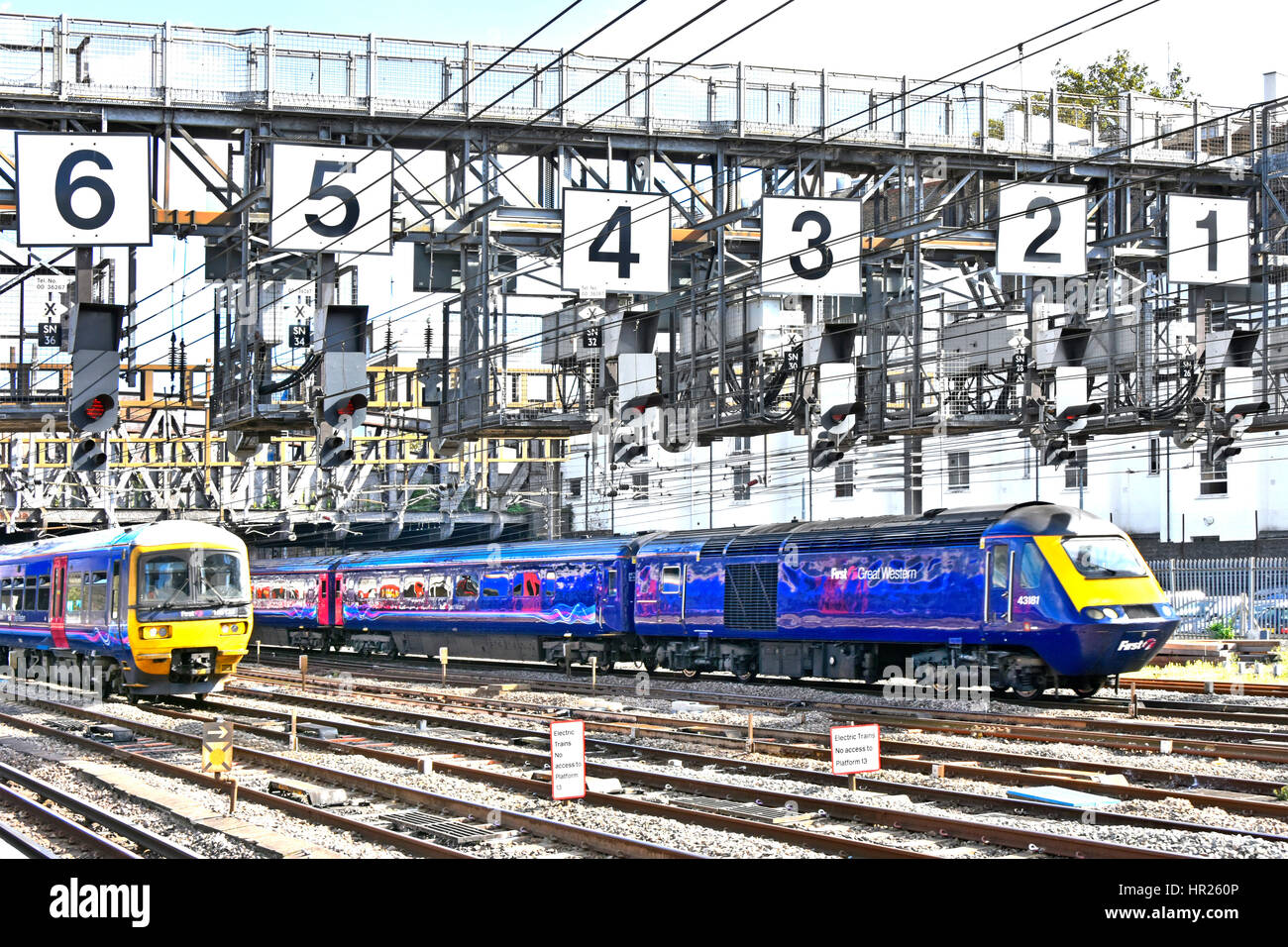 Two Firstgroup First Great Western uk train just departed Paddington railway station London UK passing under large signal gantry oversized numbers Stock Photo