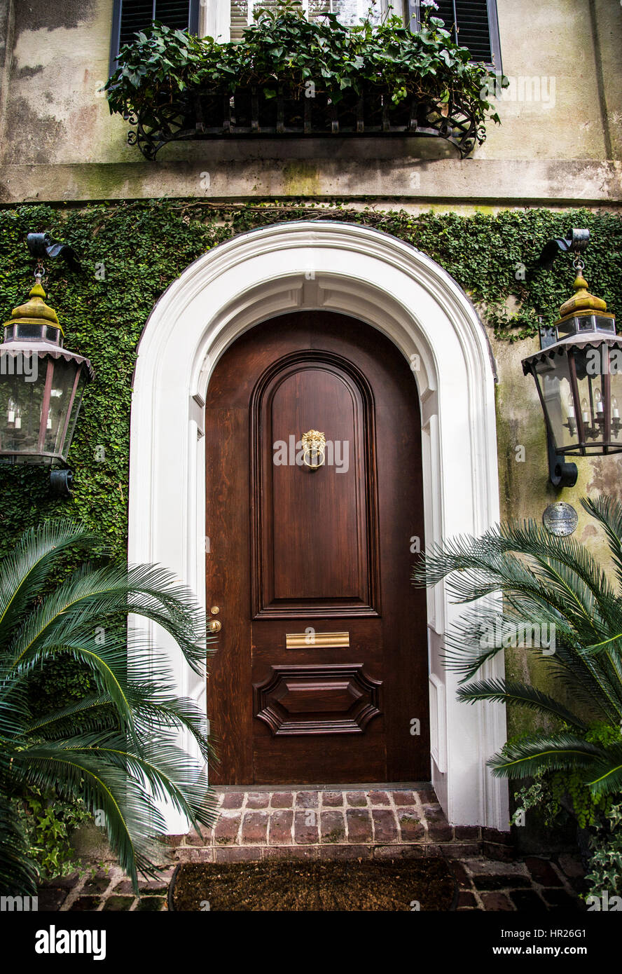 Vintage style arched wooden front door with a door knocker ...