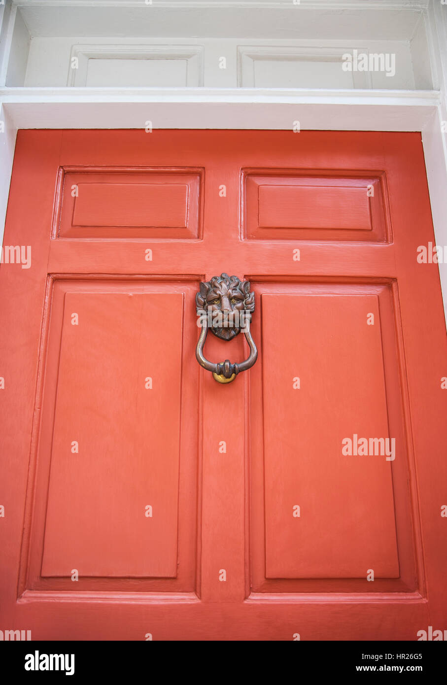 Lion door knocker on colour coral orange house front door in historic Charleston, South Carolina, US, USA, historic district gothic America PT Stock Photo