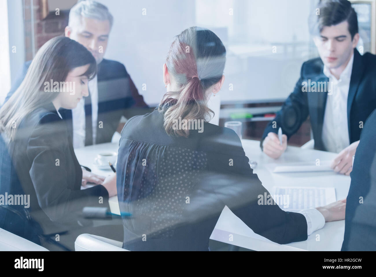 Business colleagues meeting in conference room, shot through glass Stock Photo