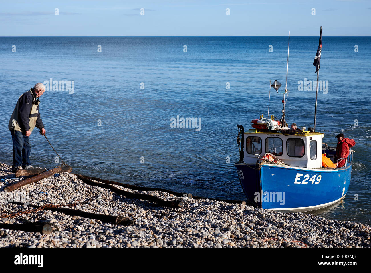 Hauling a fishing boat back on to the shore at Beer in Devon, U.K Stock