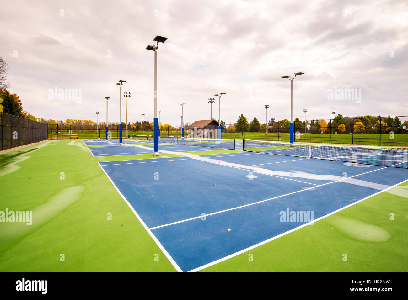 Wet tennis courts are empty after a rain shower. Stock Photo