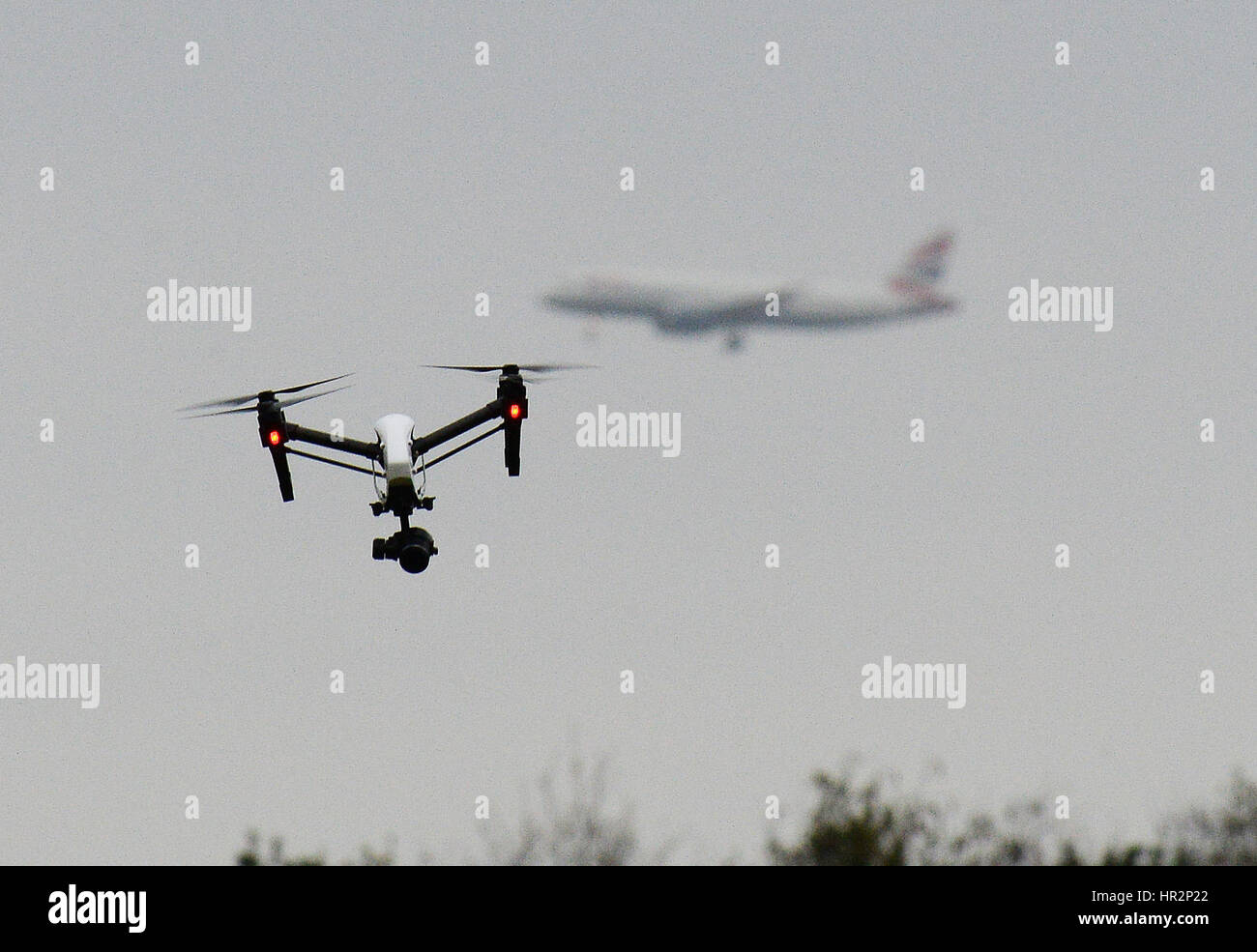 A drone flies in Hanworth Park in west London, as a British Airways 747 plane prepares to land at Heathrow Airport behind. Stock Photo