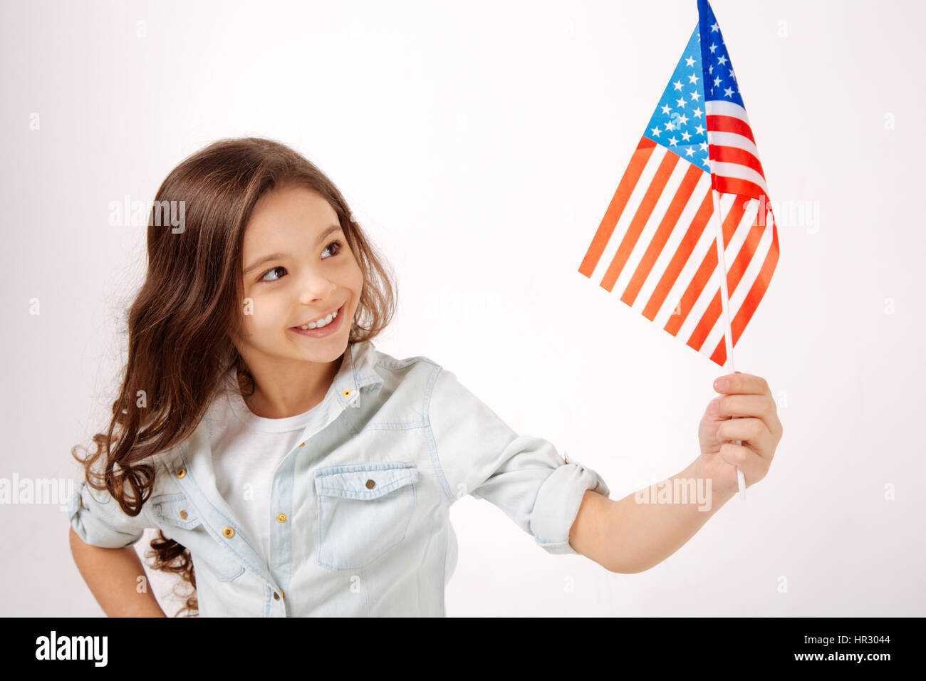 Full of joyfulness. Joyful happy cute girl holding the American flag ...