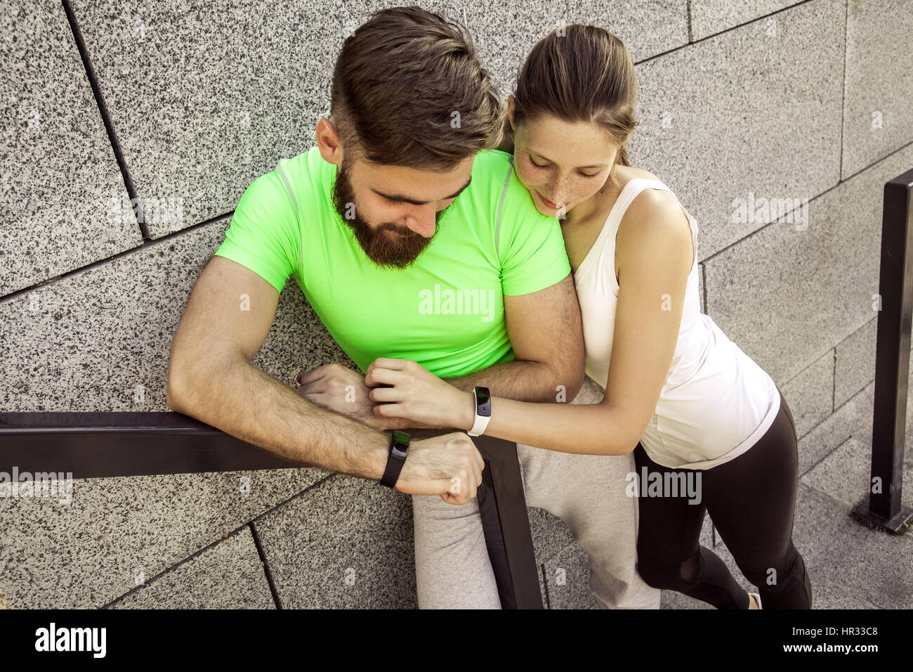 Young sporty couple are resting and check their fitness watch together. sport and technology concepts. Stock Photo