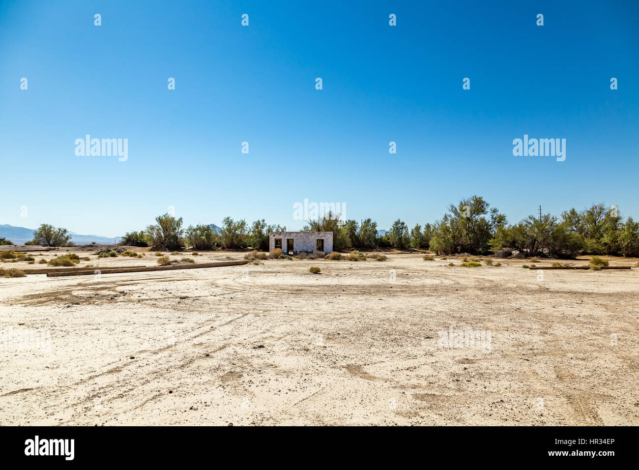 An abandoned building sits alongside the roadway near Death Valley Junction in the Funeral Mountains Wilderness Area, California. Stock Photo