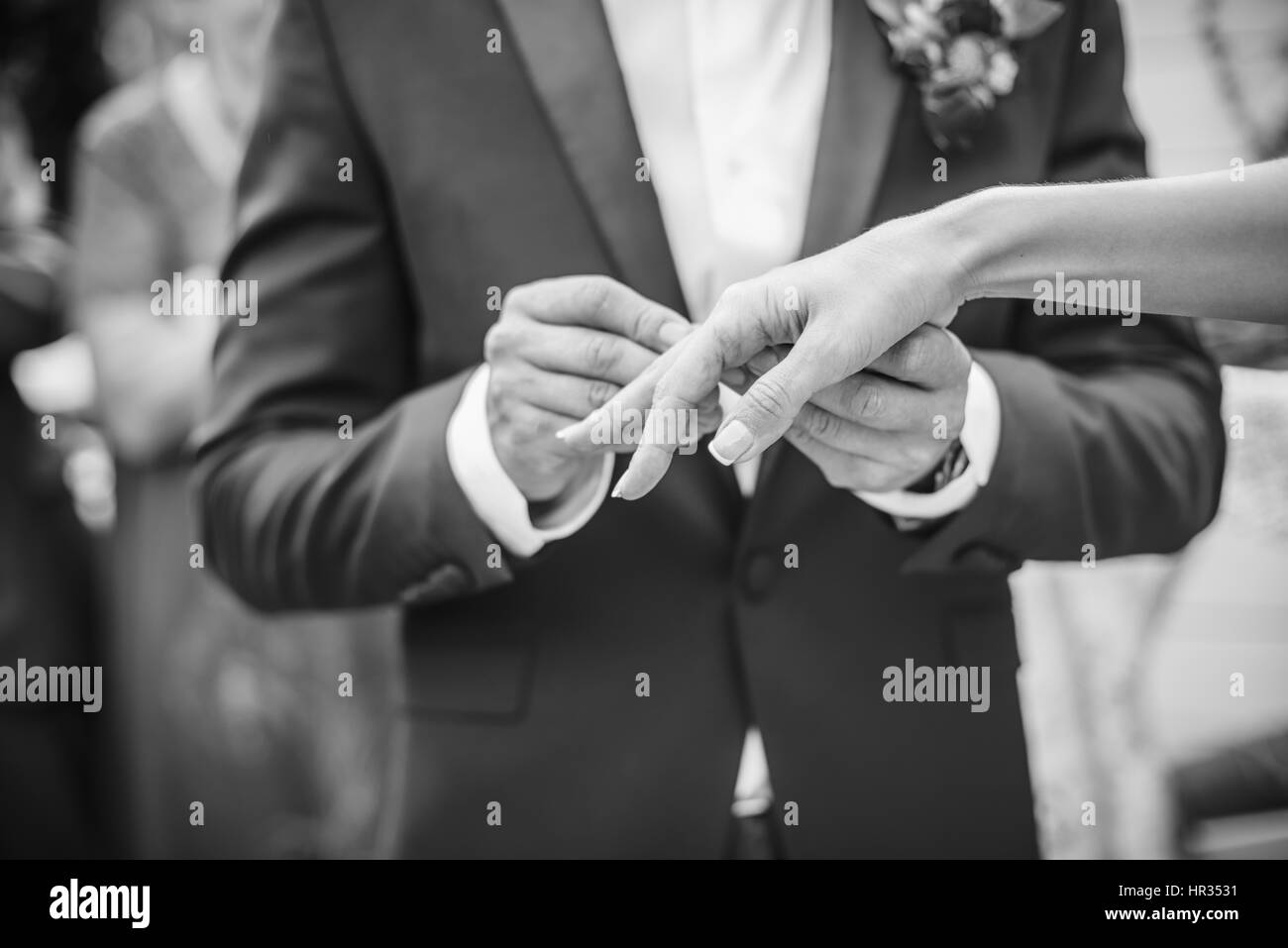 The groom wears a ring for bride. black and white photo Stock Photo