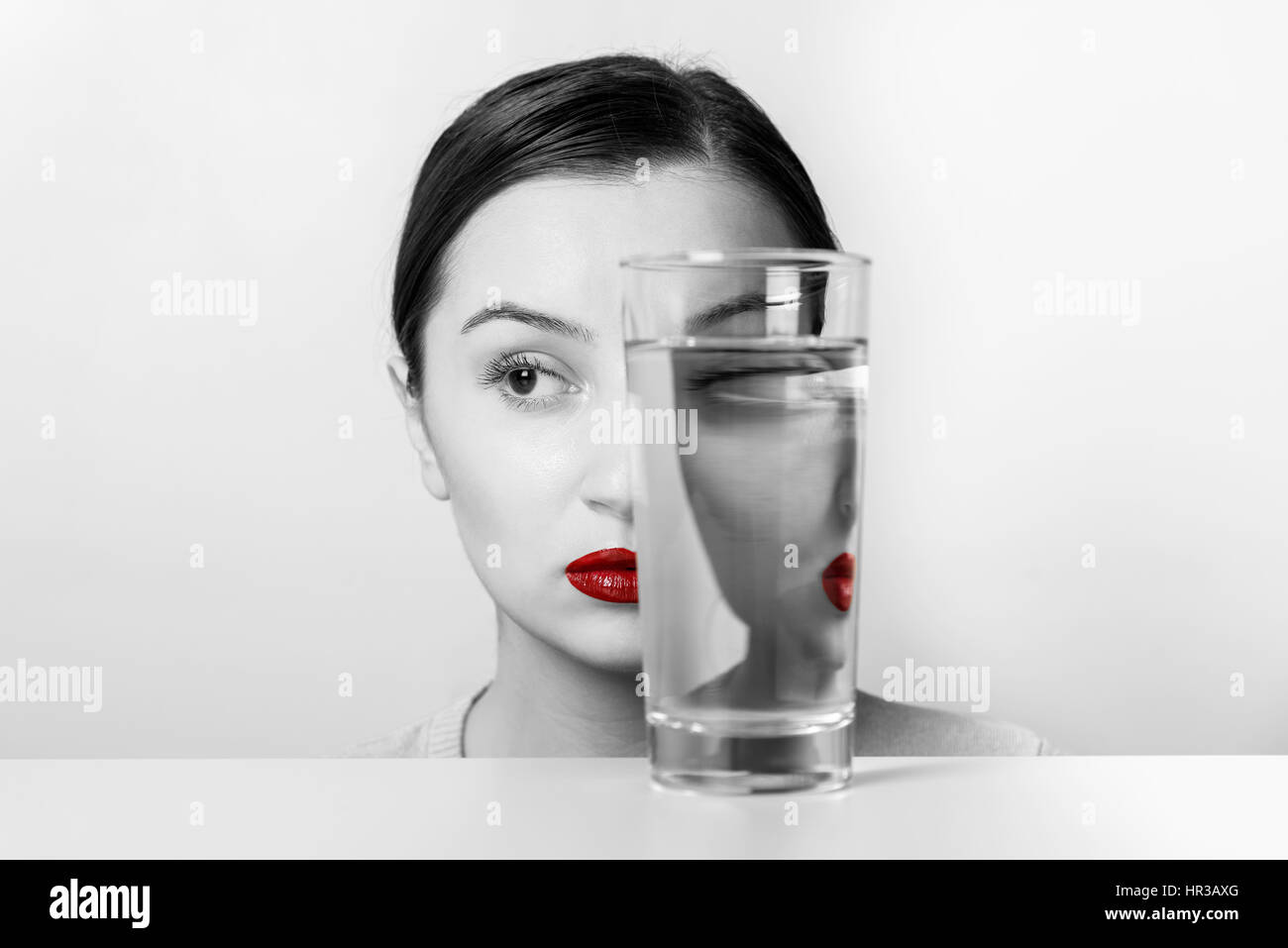 Woman Face Distortion In Glass Of Water Stock Photo