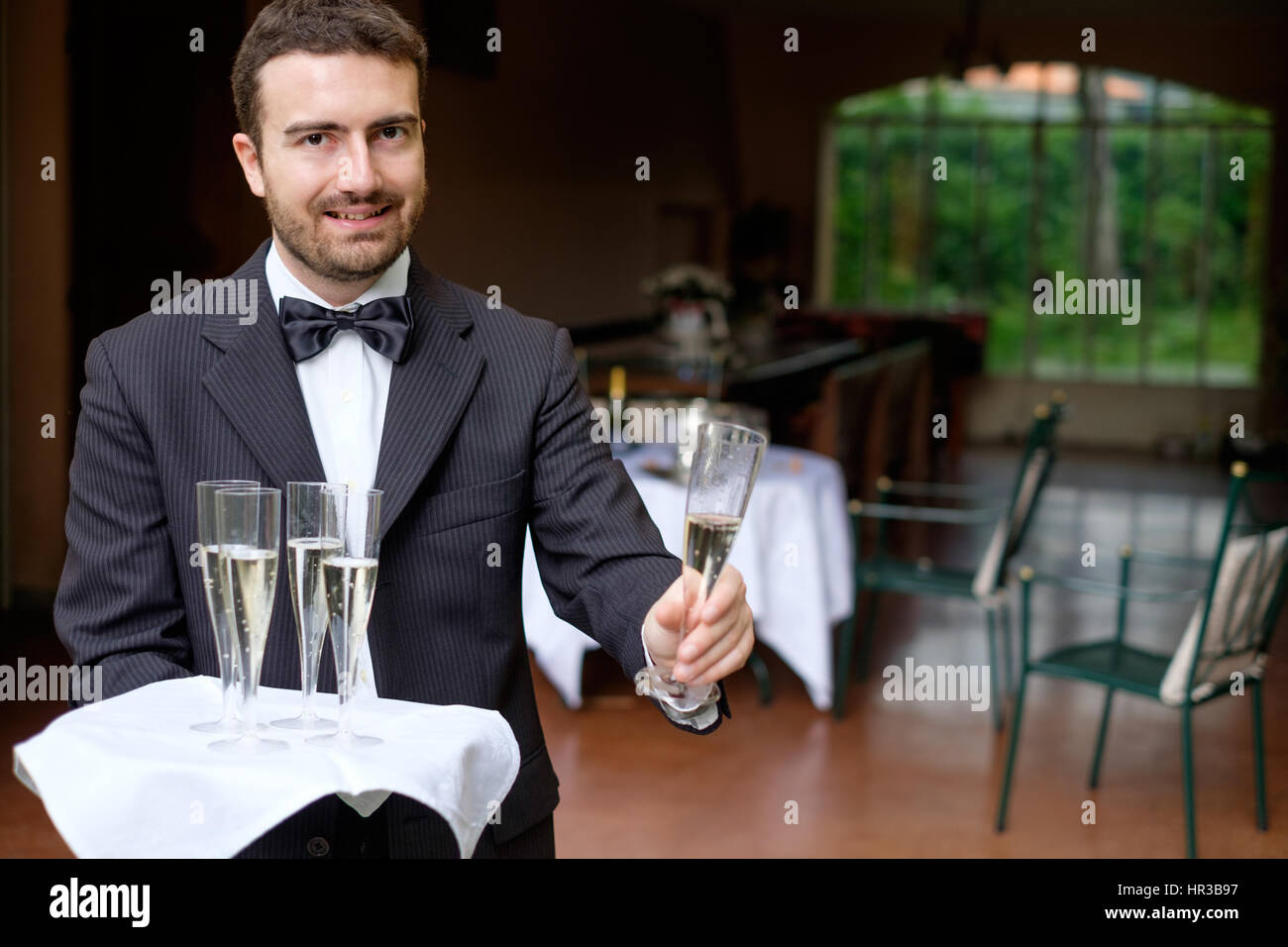 Waiter in formal dress serving champagne Stock Photo