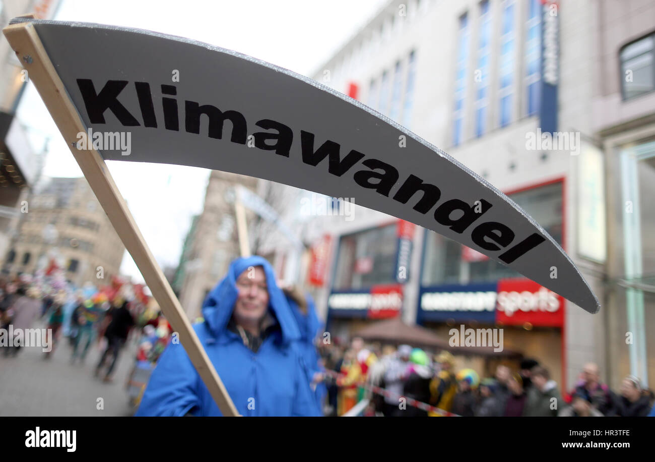Cologne, Germany. 27th Feb, 2017. A person with a scythe reading 'Klimawandel' (lit. 'climate change') participates in the traditional shrove monday carnival parade in Cologne, Germany, 27 February 2017. 'Wenn mer uns Pänz sinn, sin mer vun de Söck' (lit. 'When we see our children, we're swept off our feet') is this year's carnival motto in Cologne. Photo: Rolf Vennenbernd/dpa/Alamy Live News Stock Photo