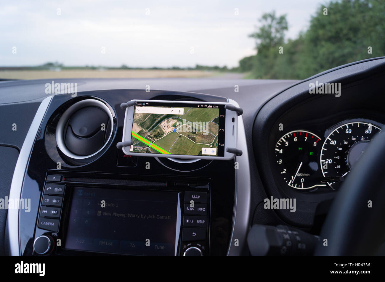 Mobile phone, smartphone on air vent mounted car cradle. Stock Photo