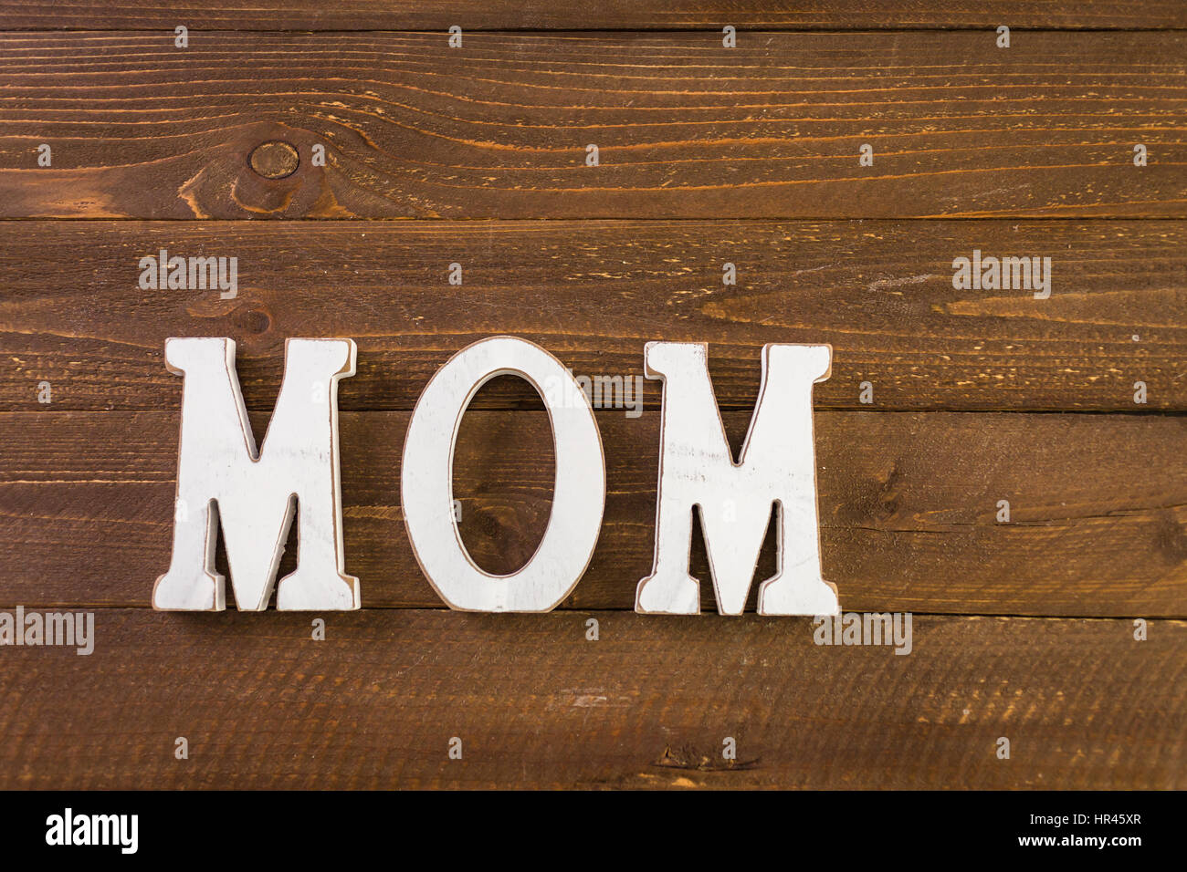 White letters MOM on a painted wood background Stock Photo - Alamy