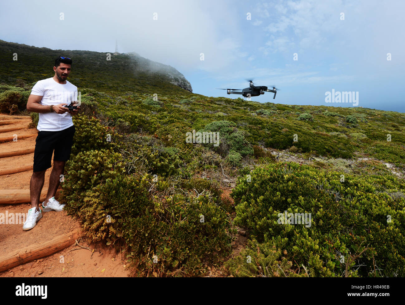 A young man operating a drone in the Cape Point national park in South Africa. Stock Photo