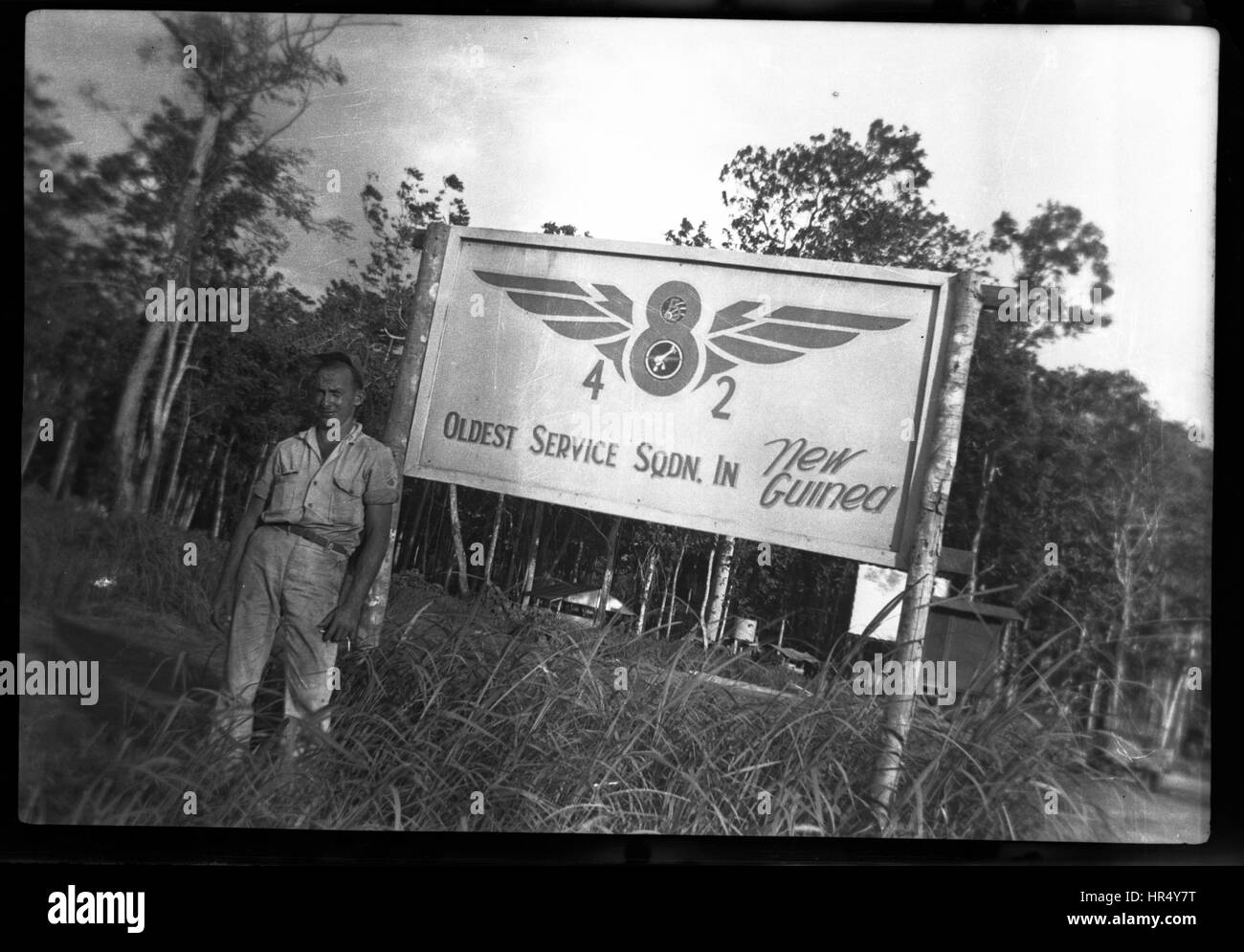 American standing on front of sign for the 8th Operations Group in New Guinea during WWII.  United States Army Air Corps Stock Photo